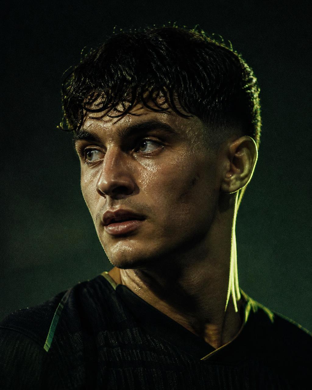 Footballer under floodlights before a night match